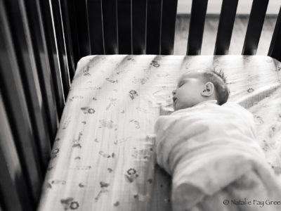 newborn baby girl sleeping peacefully in her crib