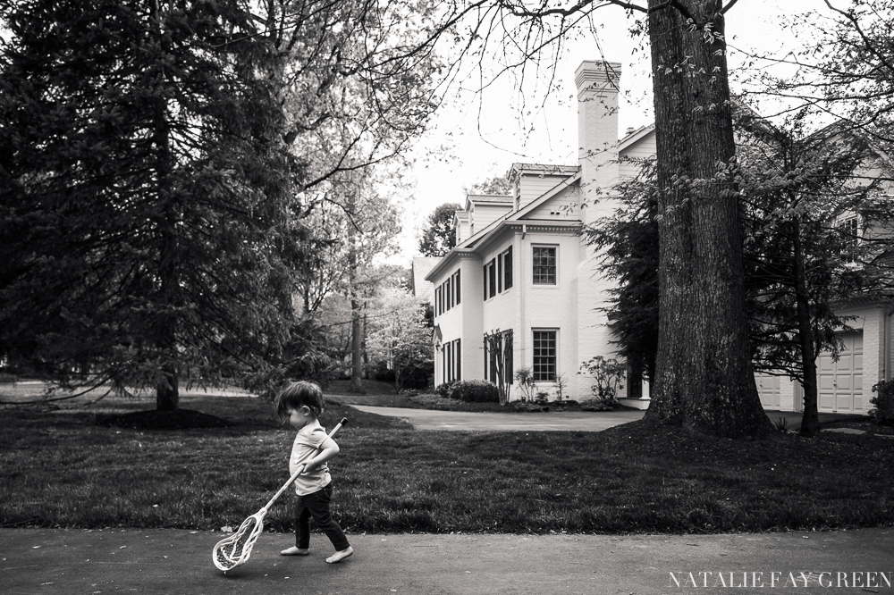 barefoot toddler walking with lacrosse stick