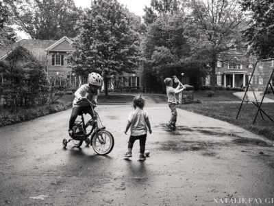 children playing in the driveway after rain | lacrosse | riding a bicycle with training wheels