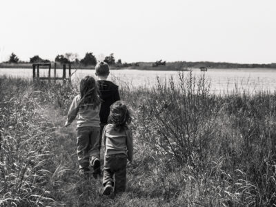 brother and younger sisters walking through march on Eastern Shore