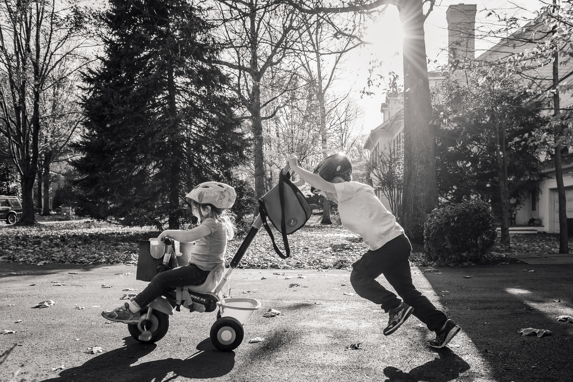 DrivewayRedo-1 brother pushing sister on tricycle